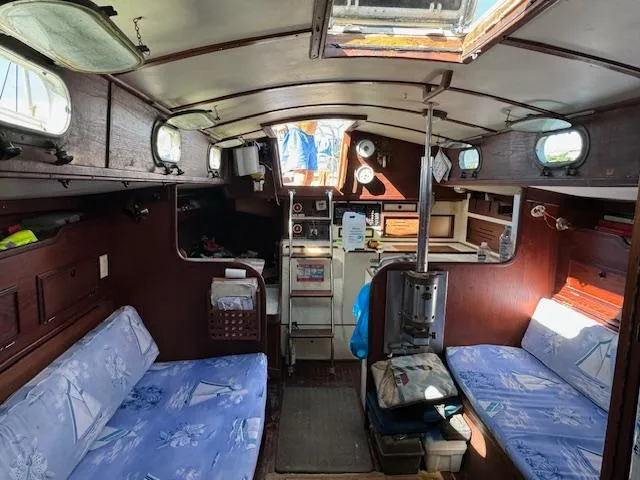 Slide: The Image of Interior of a 1980 Cape Dory 36 sailboat, featuring cozy seating and nautical decor. - 19