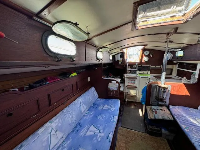 Slide: The Image of Interior of a 1980 Cape Dory 36 sailboat with wooden furnishings and blue cushions. - 22