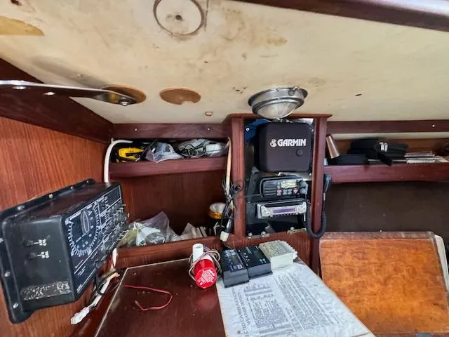 Slide: The Image of Interior of 1980 Cape Dory 36 sailboat with navigation equipment and cluttered shelves. - 25