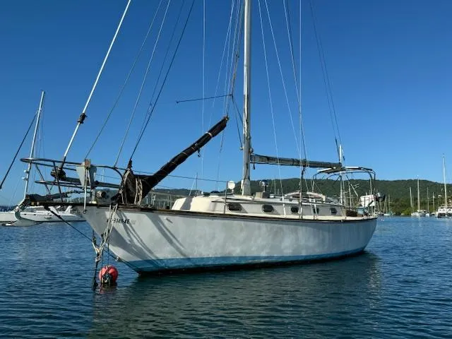 Slide: The Image of 1980 Cape Dory 36 sailboat anchored in calm waters under a clear blue sky. - 4