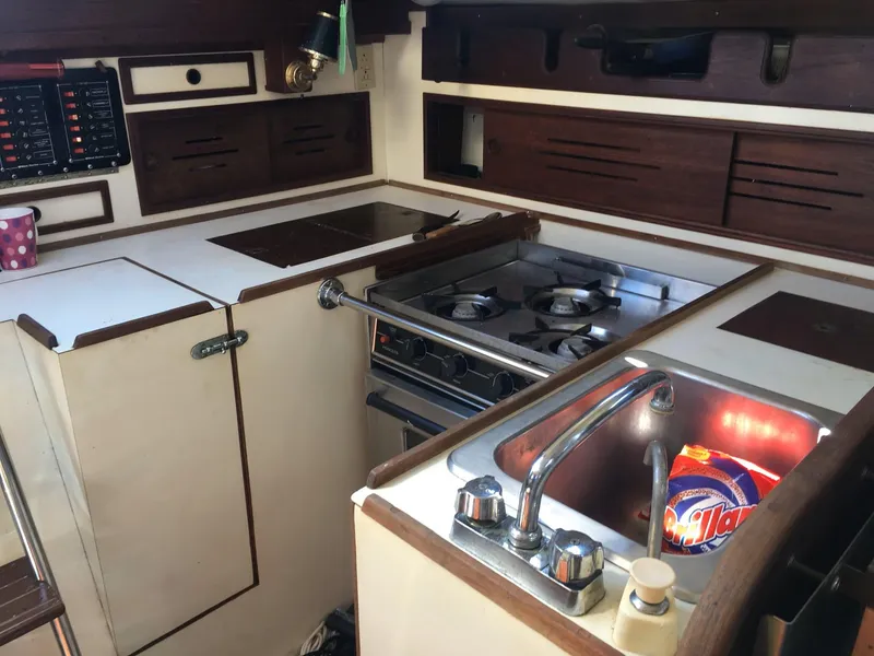 Slide: The Image of 1980 Cape Dory 36 yacht kitchen with stove, sink, and storage cabinets. - 9