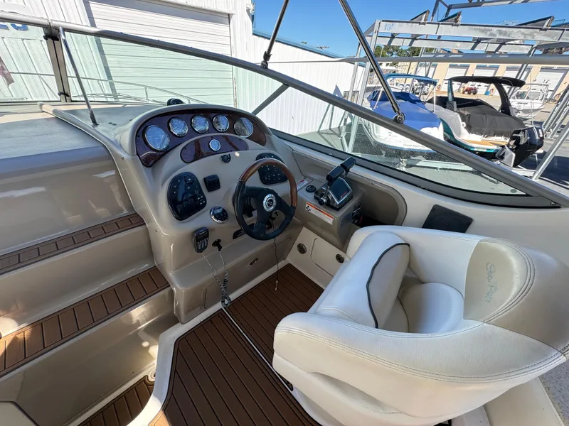 Slide: The Image of 2008 Sea Ray 280 Sundancer helm with beige interior and wood accents. - 12