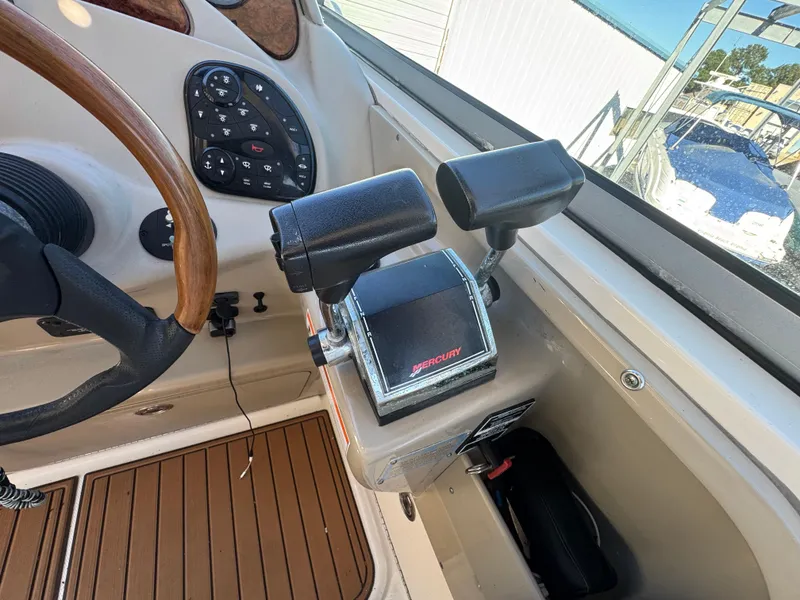 Slide: The Image of 2008 Sea Ray 280 Sundancer helm with Mercury throttle controls and wood-accented steering wheel. - 14
