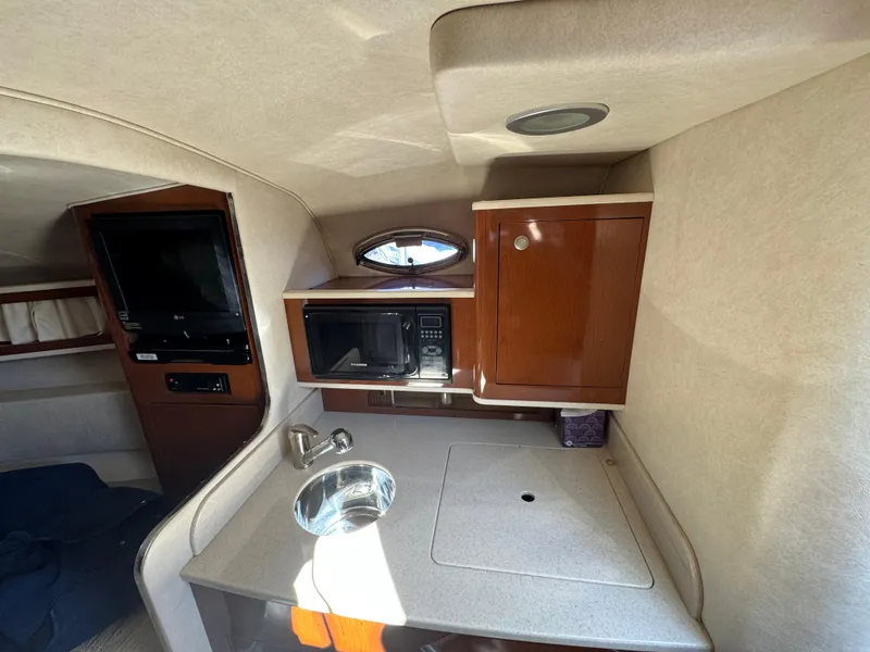 Slide: The Image of 2008 Sea Ray 280 Sundancer cabin with kitchenette, microwave, and sink. - 21