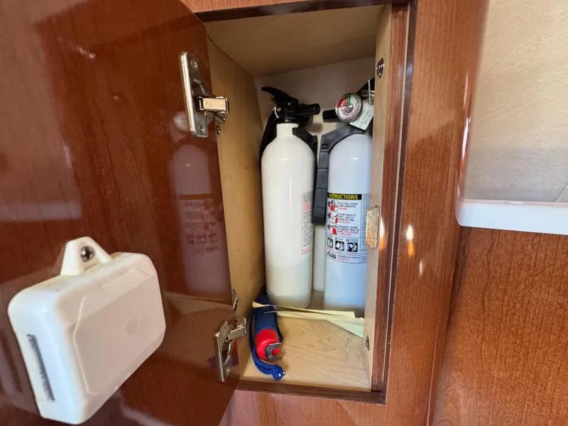 Slide: The Image of Fire extinguishers in a wooden cabinet on a 2008 Sea Ray 280 Sundancer boat. - 25