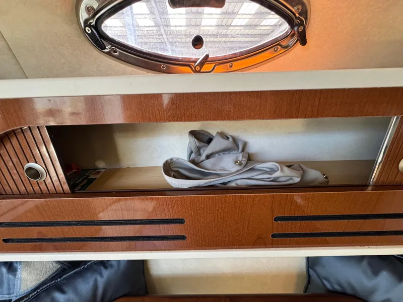 Slide: The Image of Interior storage of 2008 Sea Ray 280 Sundancer with wooden finish and porthole. - 26