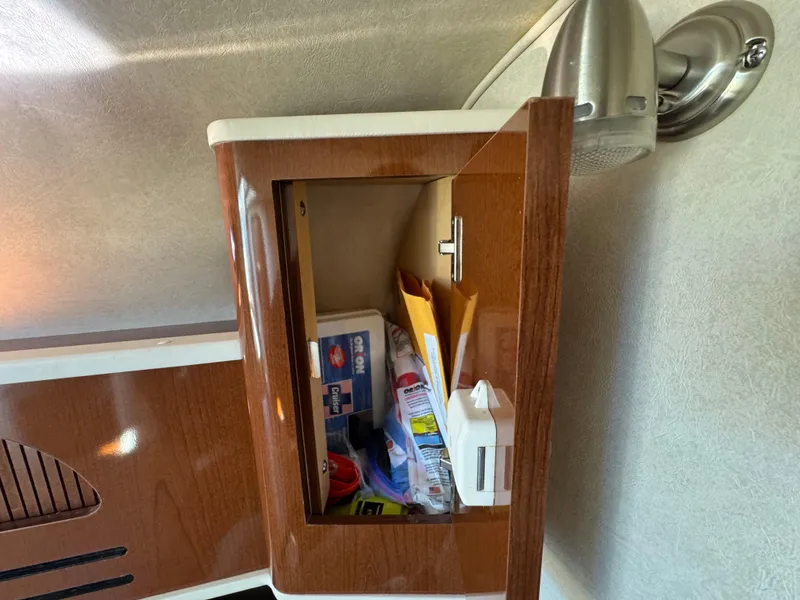 Slide: The Image of Open cabinet with supplies inside a 2008 Sea Ray 280 Sundancer boat. - 27