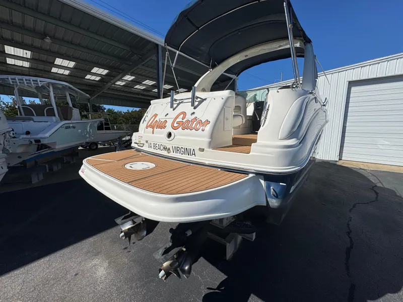 Slide: The Image of 2008 Sea Ray 280 Sundancer boat docked, featuring a spacious deck and canopy. - 7