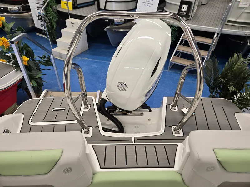 Slide: The Image of 2025 Hurricane SunDeck 2050 OB boat with outboard motor, displayed indoors. - 17