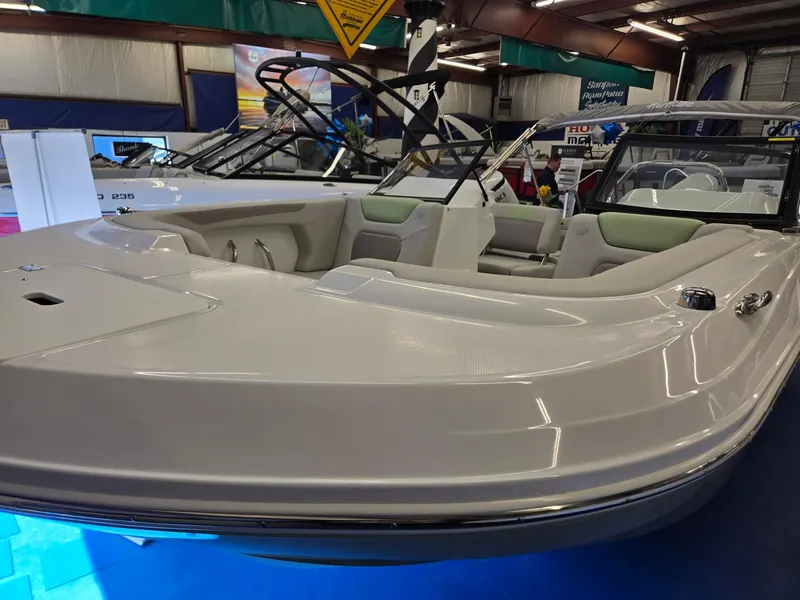 Slide: The Image of 2025 Hurricane SunDeck 2050 OB boat displayed indoors, showcasing sleek design and spacious seating. - 3