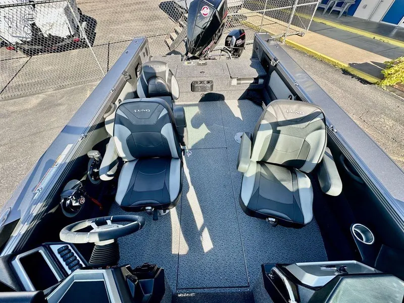 Slide: The Image of 2024 Lund 1975 Tyee Sport boat interior with two seats and steering wheel. - 9