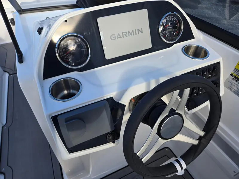 Slide: The Image of 2025 Hurricane SunDeck 235 OB boat dashboard with Garmin display and steering wheel. - 14