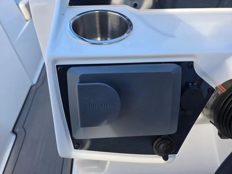 Slide: The Image of 2025 Hurricane SunDeck 235 OB boat console with Clarion audio system and cup holder. - 16