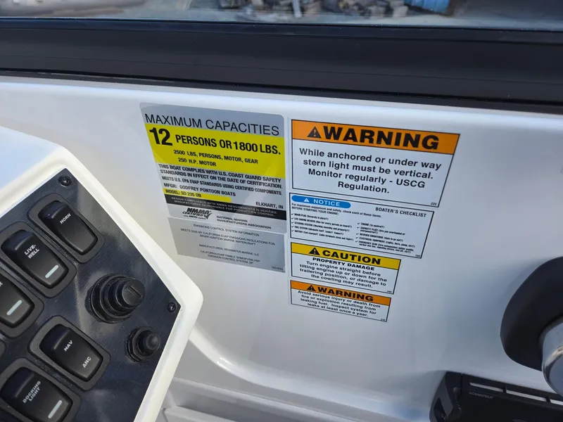Slide: The Image of 2025 Hurricane SunDeck 235 OB capacity and warning labels on boat dashboard. - 18