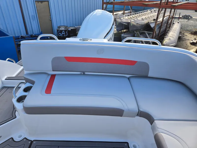 Slide: The Image of 2025 Hurricane SunDeck 235 OB boat seating area with red accents and cup holders. - 21