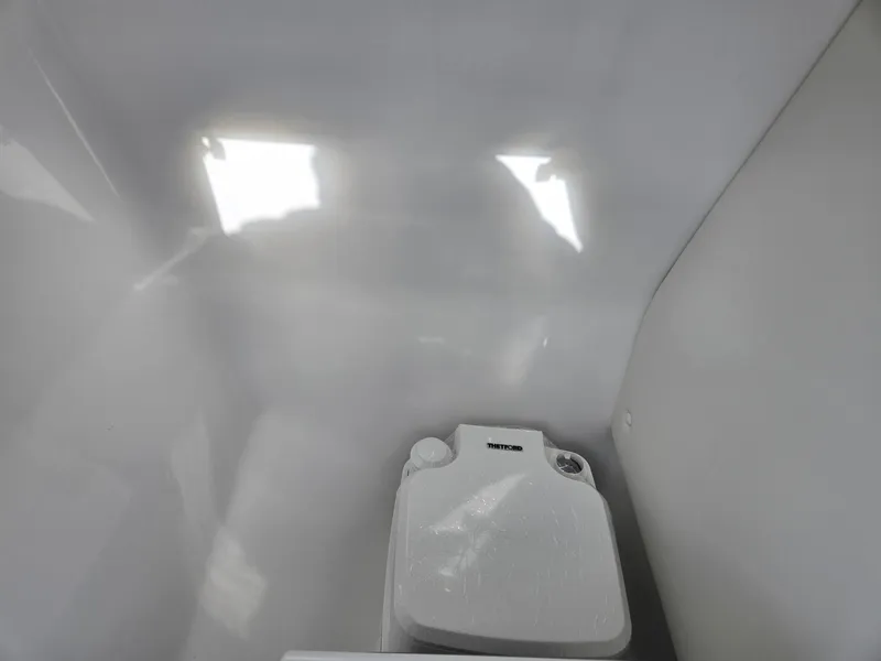 Slide: The Image of 2025 Hurricane SunDeck 235 OB boat interior with compact marine toilet. - 27