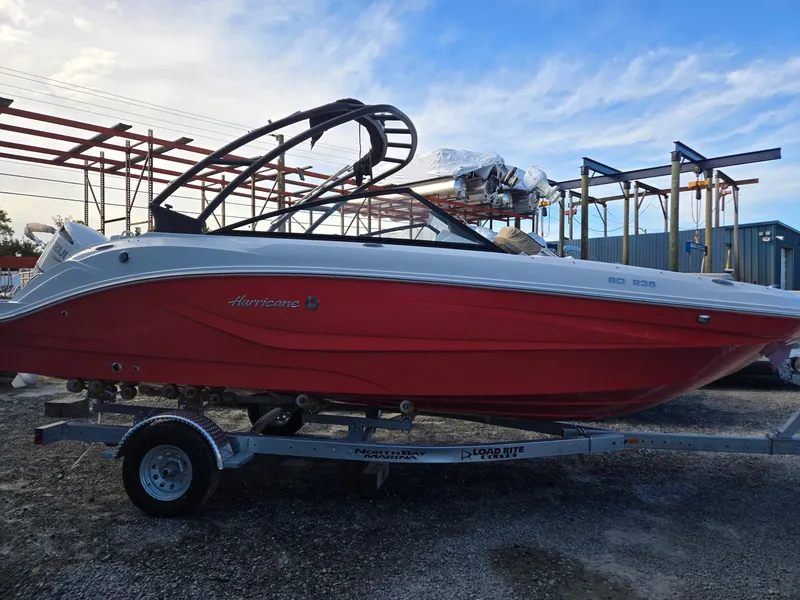 Slide: The Image of 2025 Hurricane SunDeck 235 OB boat on trailer, vibrant red hull, outdoor setting. - 3