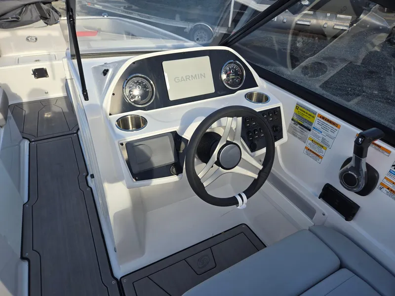 Slide: The Image of 2025 Hurricane SunDeck 235 OB boat dashboard with Garmin display and steering wheel. - 36