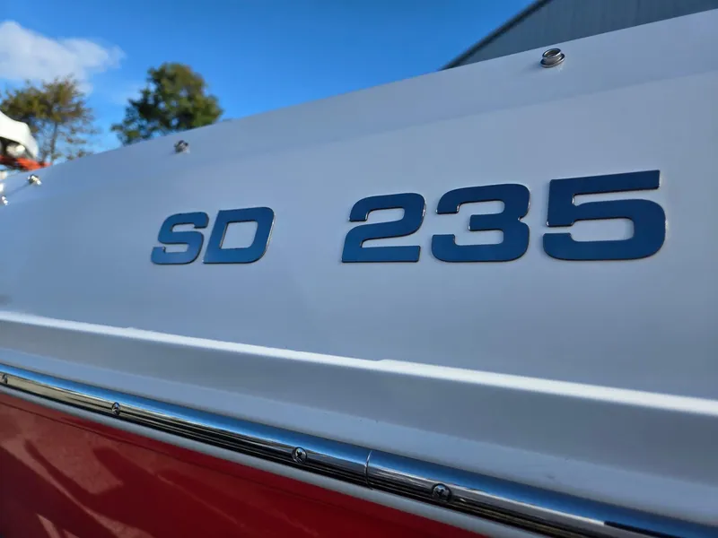Slide: The Image of 2025 Hurricane SunDeck 235 OB boat, close-up of "SD 235" lettering on hull. - 44