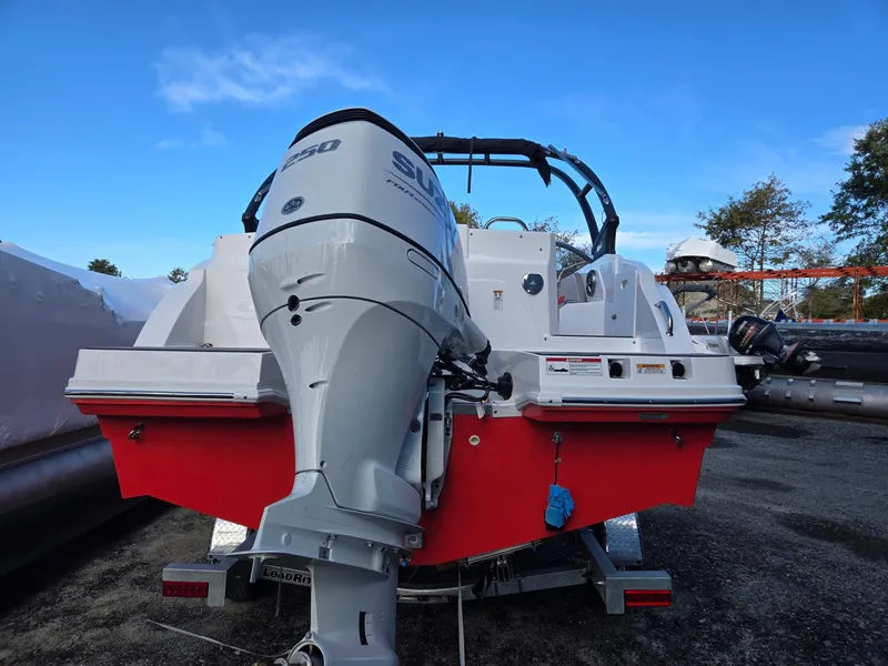 Slide: The Image of 2025 Hurricane SunDeck 235 OB boat with powerful outboard motor, parked outdoors. - 5