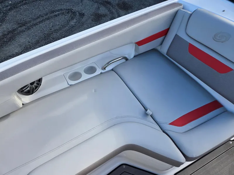 Slide: The Image of 2025 Hurricane SunDeck 235 OB boat interior with gray and red seating, cup holders, and speaker. - 8