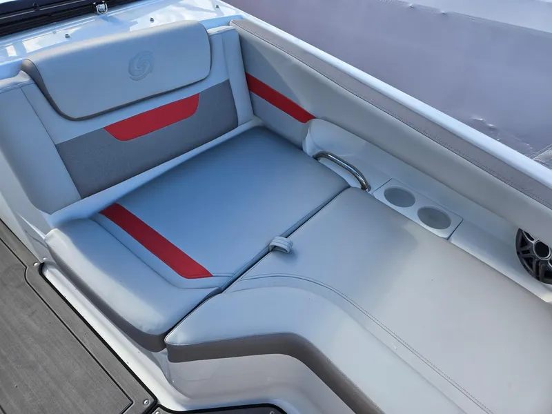 Slide: The Image of 2025 Hurricane SunDeck 235 OB boat interior with gray and red seating, cup holders, and speaker. - 9
