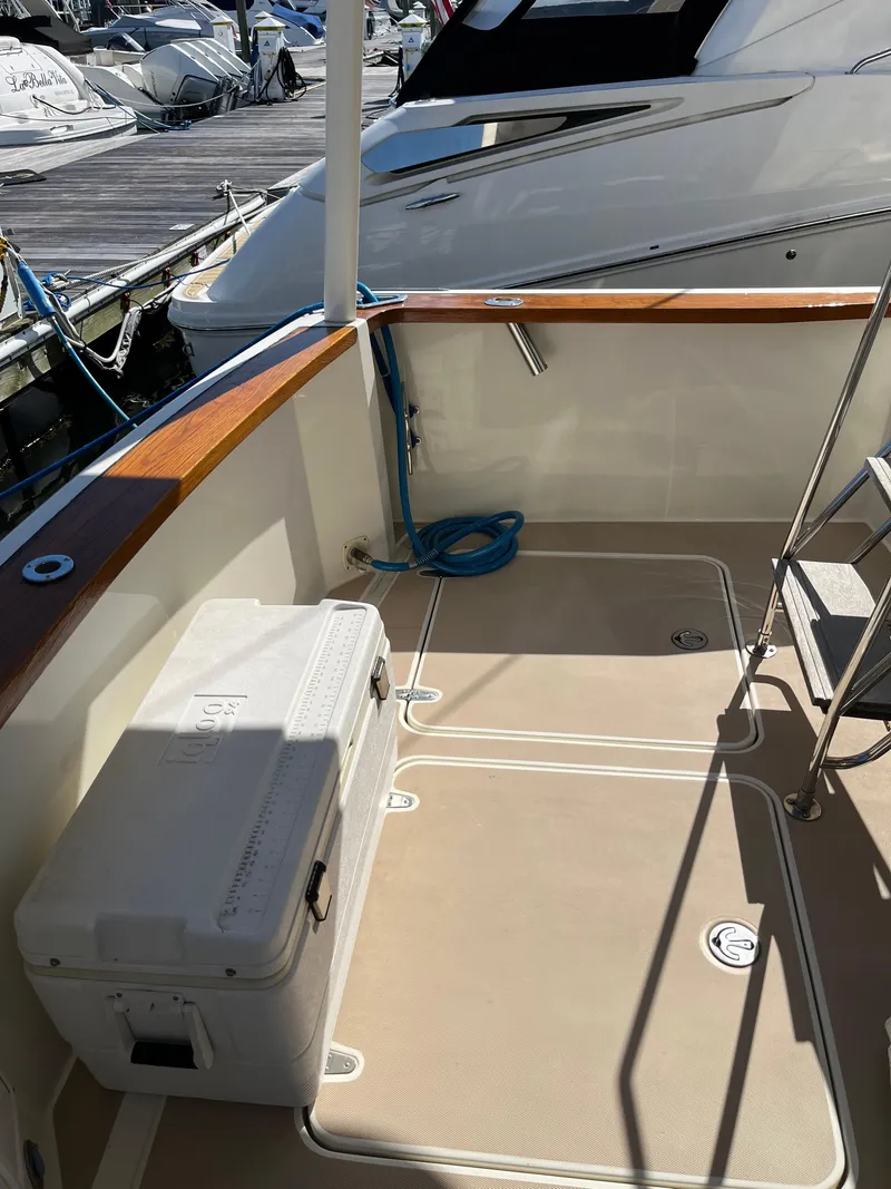 Slide: The Image of 2004 Sabre 36 Sedan boat deck with cooler and docked yacht. - 13