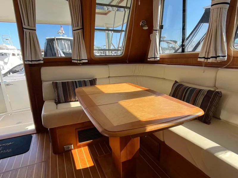 Slide: The Image of Interior of 2004 Sabre 36 Sedan with wooden table and cushioned seating. - 17