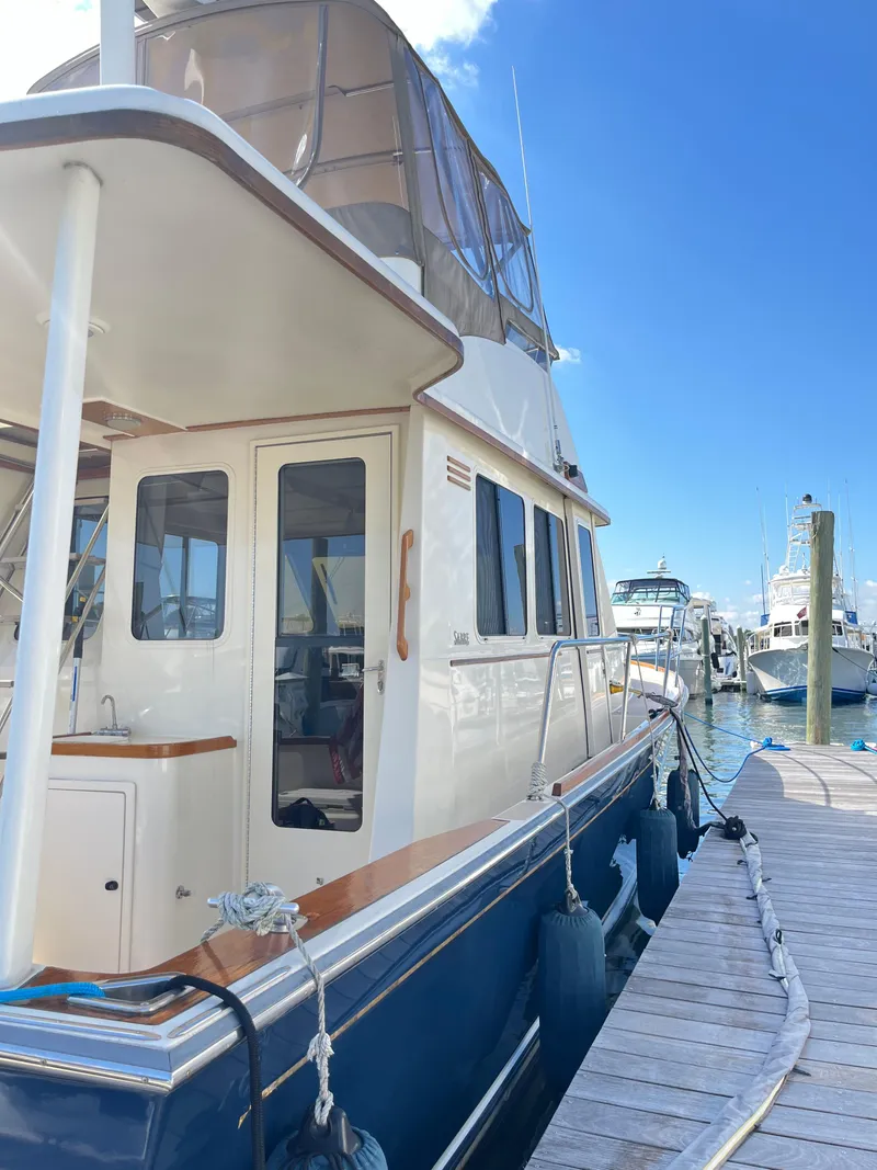 Slide: The Image of 2004 Sabre 36 Sedan yacht docked at marina under clear blue sky. - 2
