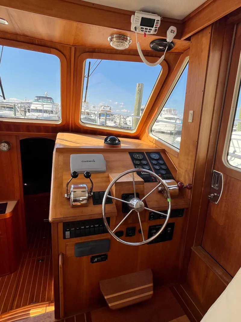 Slide: The Image of 2004 Sabre 36 Sedan helm with wooden interior and marina view. - 20
