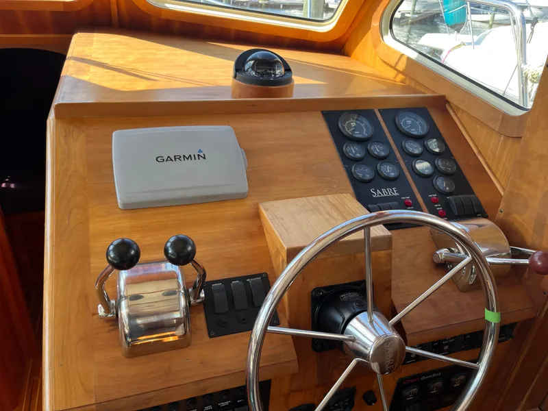 Slide: The Image of 2004 Sabre 36 Sedan helm with Garmin navigation and classic wooden steering wheel. - 22