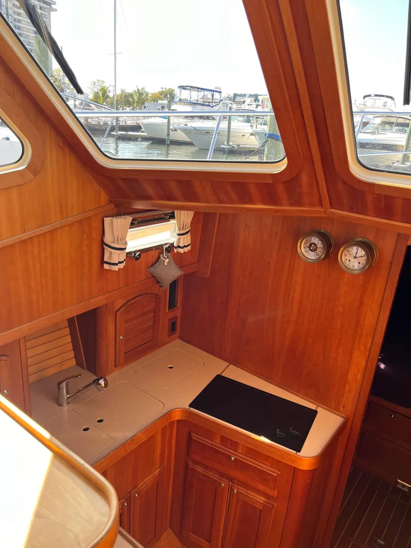 Slide: The Image of 2004 Sabre 36 Sedan yacht interior with wooden cabinetry and kitchenette. - 23