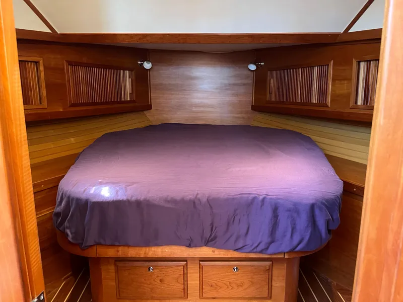Slide: The Image of Cozy cabin interior of 2004 Sabre 36 Sedan with wooden finish and purple bedding. - 28