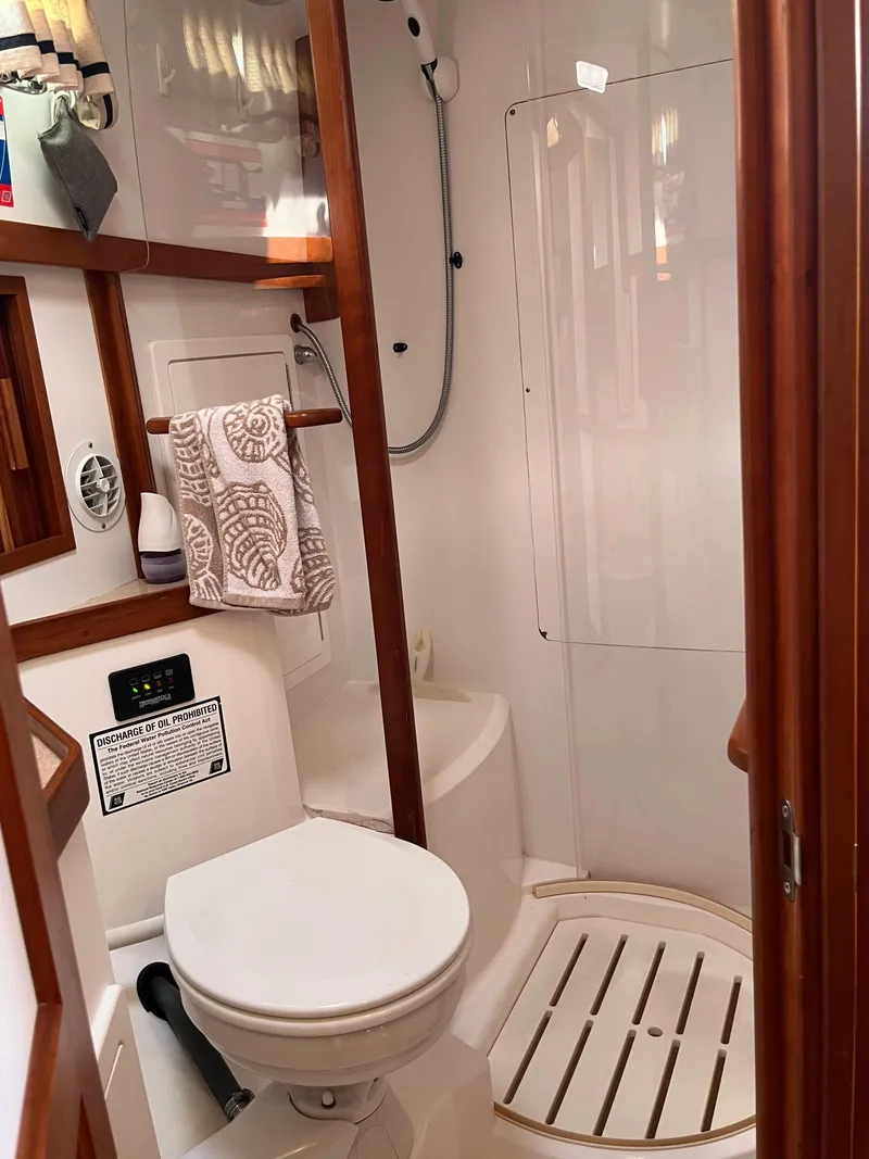 Slide: The Image of 2004 Sabre 36 Sedan bathroom with shower, toilet, and wooden accents. - 30