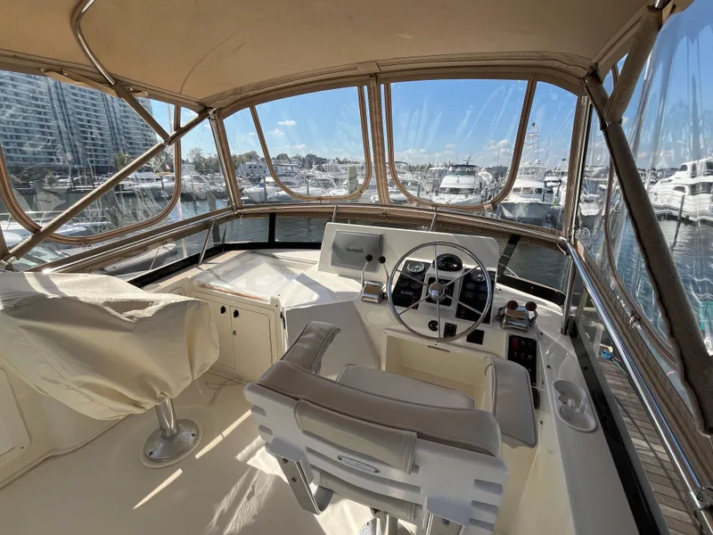 Slide: The Image of 2004 Sabre 36 Sedan helm with marina view, featuring dual seats and navigation controls. - 32