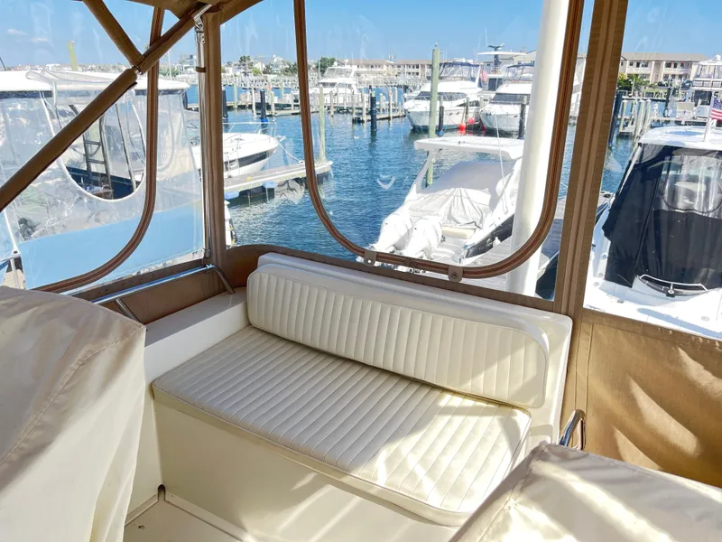 Slide: The Image of 2004 Sabre 36 Sedan interior with marina view, featuring a white cushioned seat. - 37