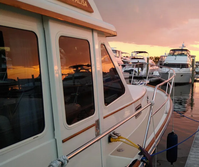Slide: The Image of 2004 Sabre 36 Sedan yacht docked at sunset with reflections on water. - 38