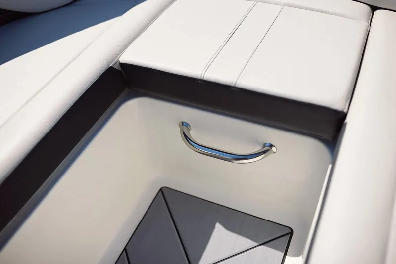 Slide: The Image of 2024 Sea Ray 210SPX boat storage compartment with sleek handle and cushioned seating. - 16