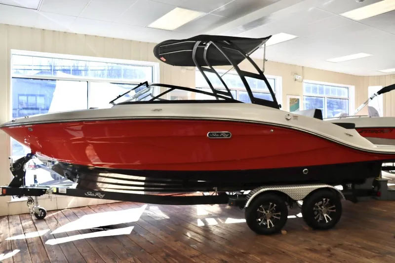 Slide: The Image of 2024 Sea Ray 210SPX boat with red hull on display indoors. - 3