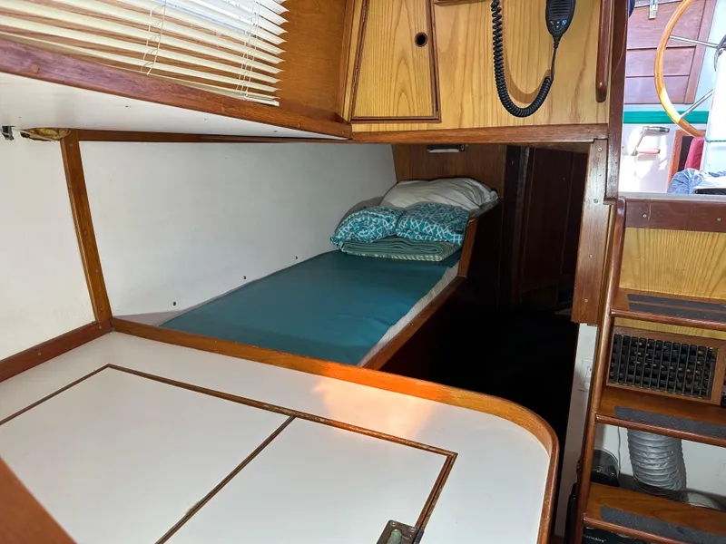Slide: The Image of 1978 Rival 41C boat interior with wooden cabinetry and a cozy sleeping berth. - 14