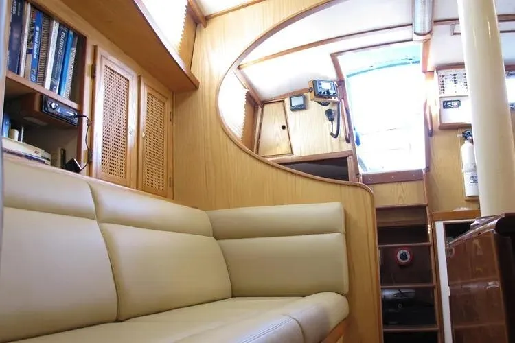 Slide: The Image of Interior of a 1978 Rival 41C yacht with beige seating and wooden cabinetry. - 18