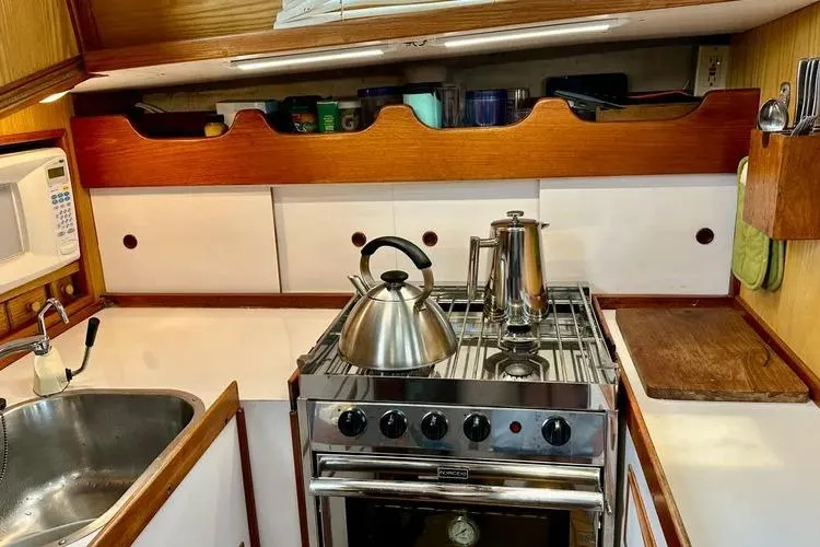 Slide: The Image of Vintage 1978 Rival 41C yacht kitchen with stove, kettle, and sink. - 19