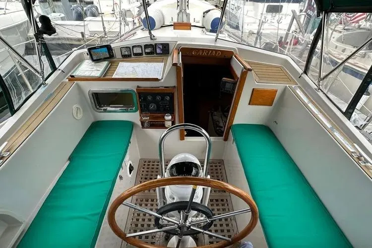 Slide: The Image of 1978 Rival 41C sailboat cockpit with green cushions and wooden steering wheel. - 20