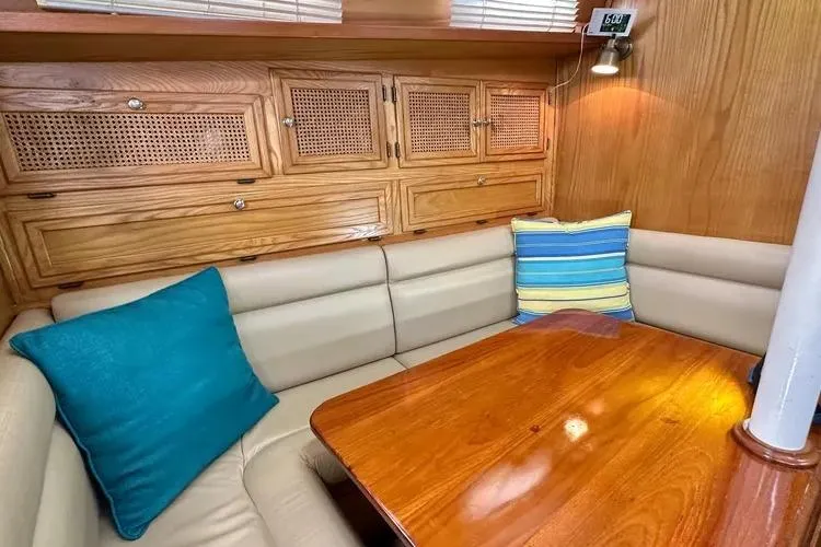 Slide: The Image of Cozy 1978 Rival 41C sailboat interior with wooden cabinets and cushioned seating. - 22