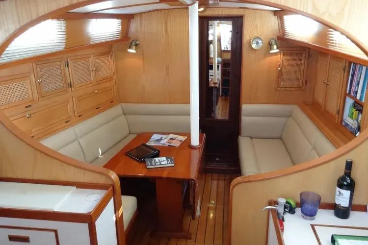 Slide: The Image of Cozy interior of 1978 Rival 41C sailboat with wooden furnishings and seating area. - 23