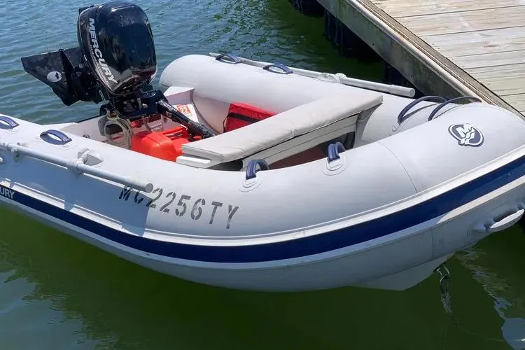 Slide: The Image of Inflatable boat with Mercury motor, docked on water; Rival 41C, 1978 model. - 25