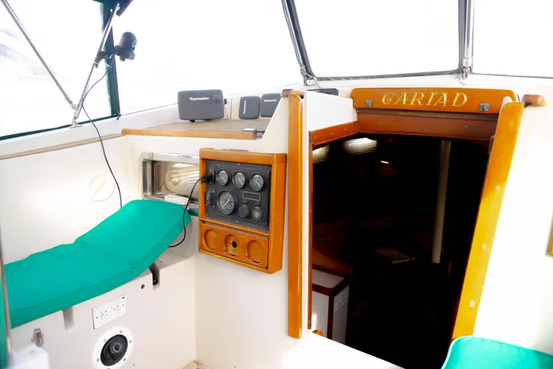 Slide: The Image of 1978 Rival 41C yacht cockpit with green cushions and wooden paneling. - 38