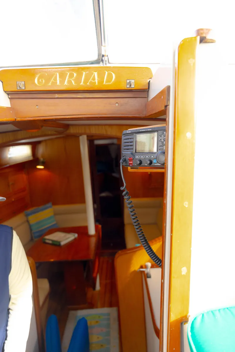 Slide: The Image of Interior view of a 1978 Rival 41C sailboat, featuring cozy wooden furnishings and a navigation device. - 42