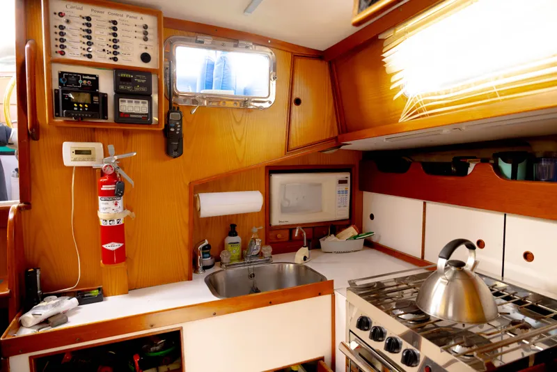 Slide: The Image of 1978 Rival 41C yacht kitchen with stove, sink, and control panel. - 45