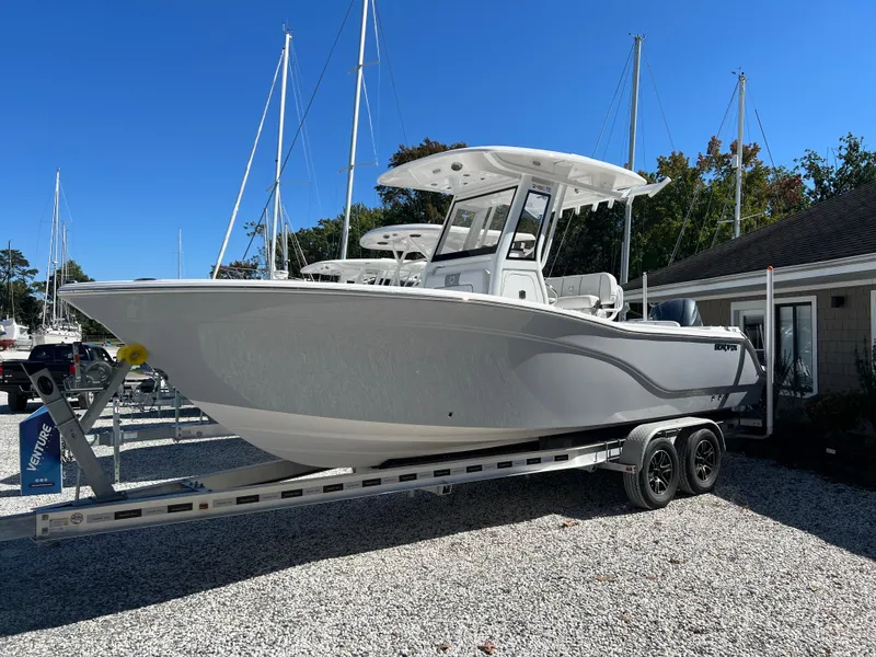 Slide: The Image of 2025 Sea Fox 248 Commander boat on trailer, parked in marina with sailboats. - 1
